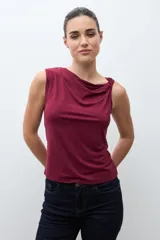 Top sin mangas color bordó con escote drapeado tipo cascada, ajustado al cuerpo.