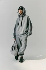 Pantalón de jogging gris de frisa con elástico ancho en cintura y puños, cordón plano ajustable, logo R11 serigrafiado y bolsillos laterales.