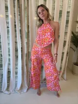 Top con estampado floral en tonos rosados y naranjas, con cuello halter y espalda descubierta.