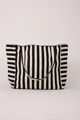 Bolso tipo tote de tela con rayas verticales en blanco y negro.