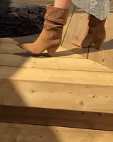 Botines dorados de cuero vacuno con punta fina y tacón aguja.