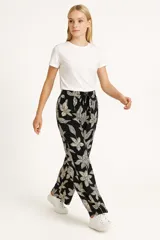 Pantalón babucha marrón con estampado floral en tonos beige, con cintura elástica ajustable con cordón.
