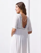 Kaftan blanco largo con mangas cortas y abertura central. Presenta apliques de puntilla en el escote, cintura y ruedo. Se ata en la cintura con un lazo.