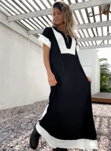 Vestido largo negro con paneles blancos en escote, mangas y ruedo.