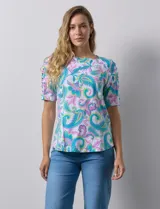 Remera estampada con diseño paisley en tonos celeste, rosa, amarillo y verde. Tiene mangas cortas con detalle de aberturas y lazos en los hombros.
