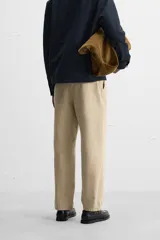 Pantalón color arena de corte recto, confeccionado en tejido de algodón con estructura canvas. Cuenta con cintura ajustable con trabillas laterales, bolsillos frontales y traseros de vivo. Cierre frontal con cremallera y botón.