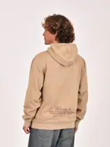 Hoodie color beige con capucha y bolsillo canguro frontal. Presenta un estampado minimalista en color marrón en el pecho con texto que incluye "GR Trademark", "Unfiltered Content" y "worldwide".