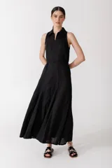 Vestido midi negro con cuello camisero, sin mangas y cierre frontal con cremallera.