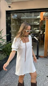 Vestido corto blanco de corte evasé, con escote cuadrado y mangas cortas abullonadas.