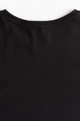 Remera deportiva corta de corte holgado, color negro, con cuello redondo y mangas cortas con hombros caídos.