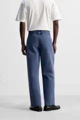 Pantalón azul de corte recto, con cintura ajustable, bolsillos laterales y traseros, y bolsillo tipo plastrón en la pierna. Tiene un lavado vintage con efecto de manchas.