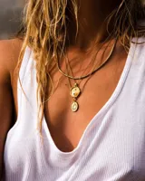 Collar dorado con dije de sol y dije de yin yang.