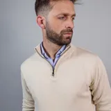 Buzo de punto color azul marino, con cuello alto y medio cierre frontal.