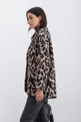 Tapado cruzado oversize confeccionado en paño con estampado de leopardo, con botones frontales y bolsillos aplicados.
