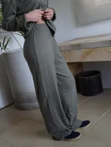 Pantalón verde de corte ancho y tiro alto, con textura acanalada.