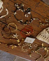 Collar artesanal con dije de flor plateada, realizado con hilo de seda natural teñido a mano.