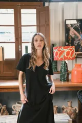 Vestido largo de tejido acanalado, con diseño bicolor vertical: mitad negro y mitad beige claro. Tiene mangas cortas y escote en V.