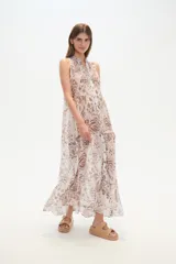 Vestido largo holgado de viscosa, sin mangas, con cuello en V y abotonadura frontal. Presenta un estampado en tonos fucsia, rosado y blanco con motivos étnicos o ikat.