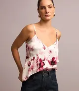 Blusa de viscosa satinada con estampado floral, breteles finos ajustables, escote en pico y volado diagonal.