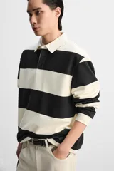 Sudadera tipo polo con cuello clásico, manga larga y diseño a rayas horizontales en color verde oscuro y crudo.