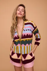 Saco de algodón tejido a mano con jacquard, silueta holgada, escote en V y manga larga. Largo por debajo de la cola con terminaciones con bordado.