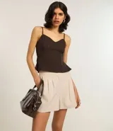 Short color beige de sastrería con pliegues delanteros, trabillas en la cintura, bolsillos tipo cuchillo en el lateral y embutidos en la parte de atrás.