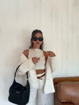 Bandolera negra de cuero sintético con asa de hombro y correa regulable. Cuenta con un bolsillo frontal con cierre y un bolsillo dorsal con cierre.