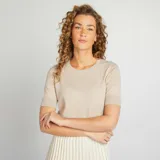 Sweater de punto color beige de manga corta y cuello redondo.