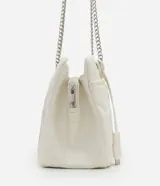 Bolso de hombro mediano color blanco con diseño acolchado en forma de rombos. Tiene asa de cadena plateada, cierre de cremallera y bolsillo frontal con botón a presión.