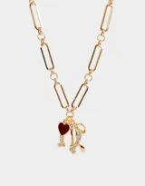 Collar dorado con cadena de eslabones grandes y dijes colgantes de corazón rojo, herradura y moño con strass.