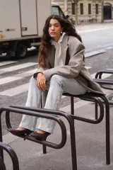 Jean acampanado de tiro bajo, color gris claro, confeccionado en denim levemente elástico.