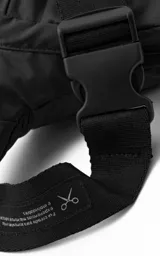 Riñonera negra con múltiples bolsillos con cierre y correa ajustable con hebilla.