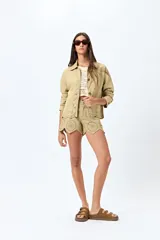 Sobrecamisa blanca de algodón con cuello camisero, botones marrones y detalles de encaje calado en el ruedo.