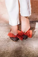 Ballerinas con estampado animal print y lazo de tul colorado con lunares dorados.