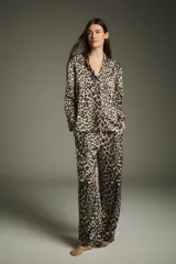 Pijama de dos piezas con estampado animal print de leopardo, compuesto por una camisa de manga larga con cuello clásico y un pantalón largo con cintura elástica.