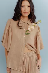 Camisa blanca de lino con cuello clásico y mangas cortas acampanadas.