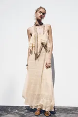 Vestido midi color crema de punto pointelle con tirantes finos y volantes en el escote.