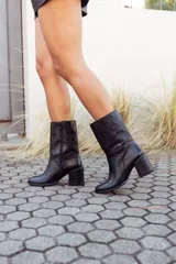 Botas de cuero negro con caña media, taco cuadrado y puntera redondeada.