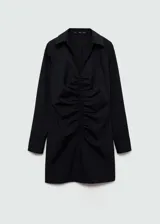 Vestido corto negro a rayas verticales finas, con cuello camisero, cierre frontal con cremallera, mangas largas con puños abotonados y detalle fruncido en el frente.