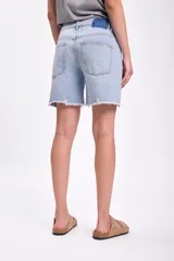 Bermuda de jean azul claro con acabado deslavado y detalles de desgaste.