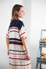 Vestido largo de tejido calado con rayas horizontales en color crudo, azul marino y rojo. Tiene tajo lateral y logo bordado en la manga.