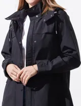 Gabardina impermeable negra, marca Weatherproof, con cierre central oculto y botones a presión. Tiene bolsillos delanteros con cierre, capucha no desmontable y forro interno de abrigo desmontable.