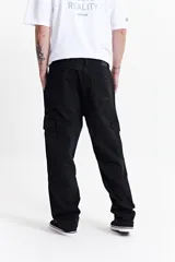 Pantalón cargo color beige, de corte recto, con bolsillos laterales y traseros. Se ajusta a la cintura con cinturón de cuero marrón.