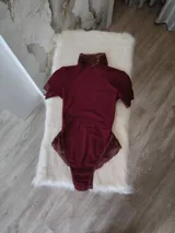 Body entallado de lycra color bordo con detalles en microtul y encaje. Con cuello alto y espalda descubierta.