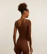 Blusa deportiva de microfibra color marrón, con escote asimétrico de un solo hombro y manga larga con recorte contrastante color beige.