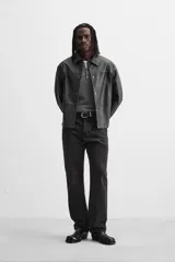 Cazadora cropped fit confeccionada en tejido efecto piel color negro. Tiene cuello solapa, manga larga con puño abotonado, bolsillos de vivo en cadera, bolsillo interior y cierre frontal con botones a presión.