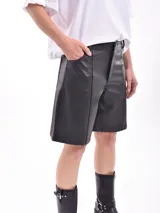 Bermuda negra de cuero sintético con cierre lateral y bolsillos.