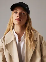 Gorra negra de algodón orgánico con logo CK metálico en el frente.