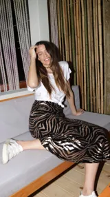 Falda midi de lentejuelas negras y doradas con estampado animal print, cintura elastizada y cierre lateral.