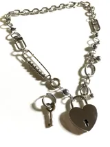 Collar plateado con cadena de eslabones, detalles de acero quirúrgico hipoalergénico y dije de candado con forma de corazón y llave.